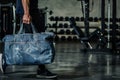 fitness enthusiast carrying denim gym bag into studio