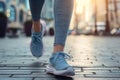 Fitness enthusiast in grey sneakers running on city pavements at dawn, a daily routine of health and active urban