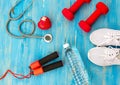 Fitness equipment gym workout and fresh water with heart and medical stethoscope on the blue background.