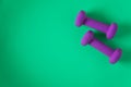 Fitness equipment with womens purple weights/ dumbbells isolated on a teal green background with copyspace Royalty Free Stock Photo