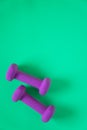 Fitness equipment with womens purple weights/ dumbbells isolated on a teal green background with copyspace Royalty Free Stock Photo