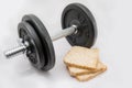 Fitness exercise equipment dumbbell weights and three fresh bread slices Royalty Free Stock Photo