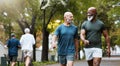 Fitness, exercise and men walking together at community park while talking and doing cardio training outdoor in nature Royalty Free Stock Photo