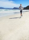 Fitness fanatic. Full length shot of a man jogging along the beach.