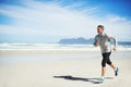 Fitness fanatic. Full length shot of a man running along the beach.