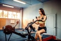 Fitness female using air bike for cardio workout at crossfit gym. Royalty Free Stock Photo