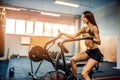 Fitness female using air bike for cardio workout at crossfit gym. Royalty Free Stock Photo