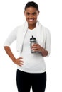 Fitness freak holding sipper, towel around her neck Royalty Free Stock Photo