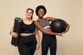 Fitness Friends. Slim And Plus Size Models. African And Caucasion Women In Black Sportswear Holding Fitness Ball And Mat.