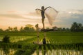 Fitness and friendship - young happy and attractive group of friends doing acro yoga workout in balance on rice field with