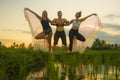 Fitness and friendship - young happy and attractive group of friends doing acro yoga workout playful on rice field with beautiful