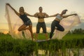 Fitness and friendship - young happy and attractive group of friends doing acro yoga workout playful on rice field with beautiful