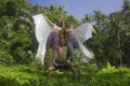 Fitness and friendship - young happy and attractive group of friends doing acro yoga workout playful on tropical jungle the girls