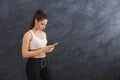 Fitness girl in earphones choosing music on phone Royalty Free Stock Photo