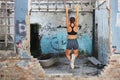 Fitness girl stretching after training in old abandoned factory