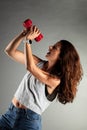 Fitness girl having fun after workout with weights. Singing and posing with red weight Royalty Free Stock Photo