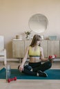 Fitness girl in at home raises the bar up at the floor. She wears yellow sporing t-shirt Royalty Free Stock Photo