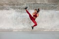 Fitness Girl Kicking. Full-Length Portrait Of Sporty Woman With Strong Muscular Body Against Concrete Wall. Royalty Free Stock Photo