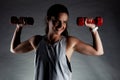 Fitness girl posing and lifting weights. Positive smiling expression