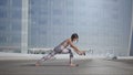 Woman standing in warrior pose at street. Girl practicing yoga on city street Royalty Free Stock Photo