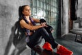 Fitness girl relaxing sitting on sports school bench after a hard boxing training.