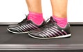 Fitness girl running on treadmill. Woman with muscular legs on w Royalty Free Stock Photo