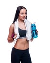 Fitness girl with shaker and towel on a white background. Attractive athletic woman relaxing after workout. Royalty Free Stock Photo