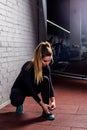 Fitness girl tying shoelace in the gym Royalty Free Stock Photo