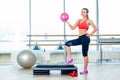 Fitness girl, wearing in sneakers, red top and black breeches, posing on step board with ball, the sport equipment Royalty Free Stock Photo