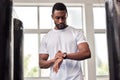Fitness, gym and black man with smart watch for time, health app or tracking wellness goals. Sports, training and Royalty Free Stock Photo