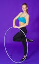 Fitness and gym concept - young sporty woman with hula hoop at gym.on a blue background Royalty Free Stock Photo