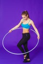 Fitness and gym concept - young sporty woman with hula hoop at gym. on a blue background Royalty Free Stock Photo