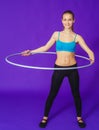 Fitness and gym concept - young sporty woman with hula hoop at gym.on a blue background Royalty Free Stock Photo