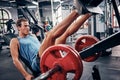 Fitness, gym and leg press, workout and weight with strong man, commitment and training with motivation, focus and Royalty Free Stock Photo