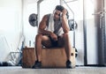 Fitness, gym and man sitting on box with smile, rest and motivation during sports workout. Health, exercise and Royalty Free Stock Photo