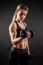 Fitness in gym, sport and healthy lifestyle concept. Beautiful athletic woman showing her trained body on black Royalty Free Stock Photo