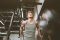 Fitness handsome man doing dipping exercise using rings in the gym