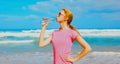 Fitness happy woman drinking water from bottle on the beach Royalty Free Stock Photo