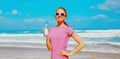 Fitness happy woman drinking water from bottle on the beach Royalty Free Stock Photo