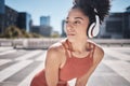 Fitness, headphones and rest, woman runner stop to relax or breathe on city run or workout. Health, urban training and Royalty Free Stock Photo