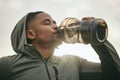 Fitness, health or black man drinking water after training, exercise or workout for body hydration. Thirsty runner