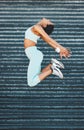 Fitness, health and woman jump in city, street or outdoors for exercise, training or wellness. Freedom, energy and happy