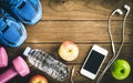 Fitness, healthy and active lifestyles Concept, Bottle of water, dumbbells, sport shoes, smartphone with headphone and apples on