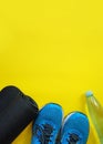 Fitness, healthy and active lifestyles Concept, sport shoes, bottle of waters, mat on yellow background. copy space for text.