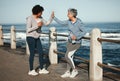 Fitness, high five and senior women by ocean for healthy lifestyle, wellness and cardio on promenade. Sports, friends