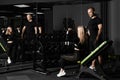 Fitness instructor conducts personal training for a girl with dumbbell in front of the mirror Royalty Free Stock Photo