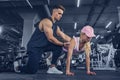 Fitness instructor help girl to do push ups on training in fitne Royalty Free Stock Photo