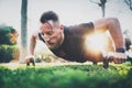 Fitness lifestyle concept.Muscular athlete exercising push up outside in sunny park. Fit shirtless male fitness model in Royalty Free Stock Photo