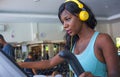 Fitness lifestyle portrait of young attractive and happy black afro American woman training at gym all doing elliptical machine