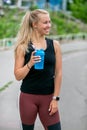 Fitness lifestyle. Sports young woman drinks water from a bottle during a training. Workout at the stadium. Healthy life concept Royalty Free Stock Photo